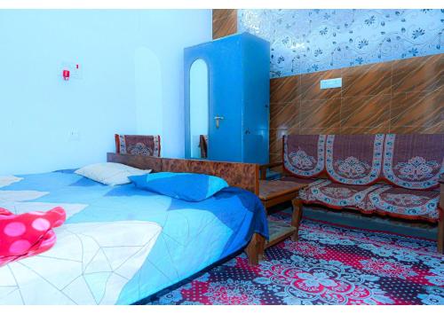 Shree Rajaram Homestay I Nearby Ram Mandir I Ayodhya في Ayodhya: غرفة نوم بسرير وجدار ازرق