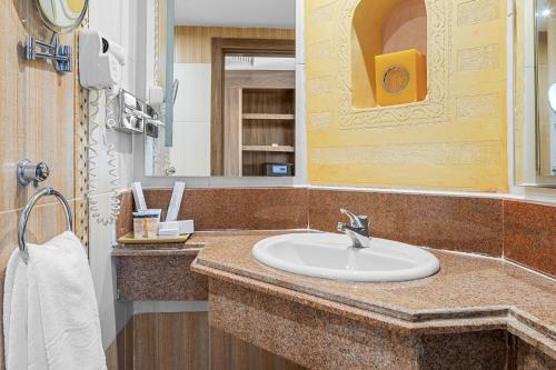 a bathroom with a sink and a mirror at Pickalbatros Palace - Aqua Park Hurghada in Hurghada