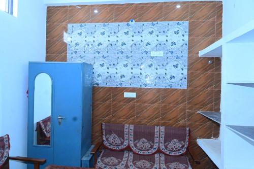 Shree Rajaram Homestay I Nearby Ram Mandir I Ayodhya في Ayodhya: غرفة بها كرسي وجدار به باب أزرق