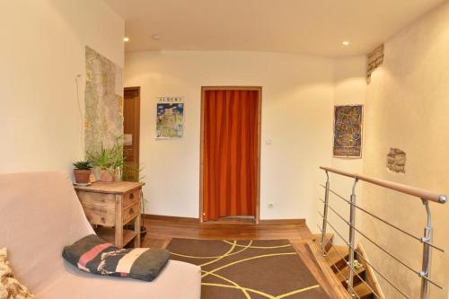 a living room with a couch and a red door at Chaleureuse maison Nancéienne in Nancy