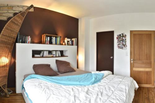 a bedroom with a large bed with a brown headboard at Chaleureuse maison Nancéienne in Nancy