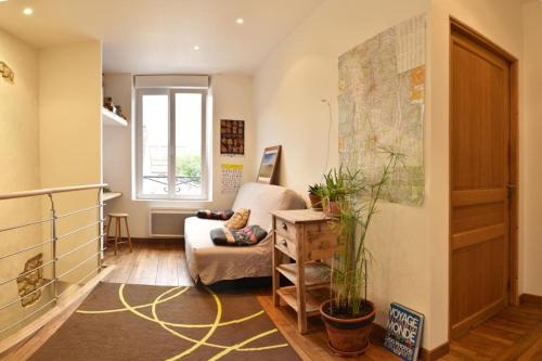 a living room with a couch and a map on the wall at Chaleureuse maison Nancéienne in Nancy