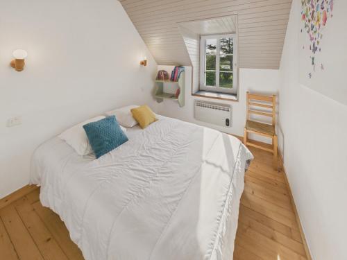 une chambre avec un lit blanc et une fenêtre dans l'établissement Agréable maison avec grand jardin pour 4, à Saint-Jean-Trolimon