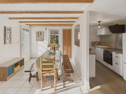 une cuisine et une salle à manger avec une table et des chaises dans l'établissement Agréable maison avec grand jardin pour 4, à Saint-Jean-Trolimon