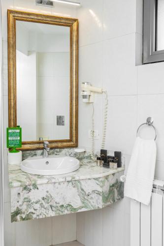 a bathroom with a sink and a mirror at Villa Boutique Lafayette in Bucharest