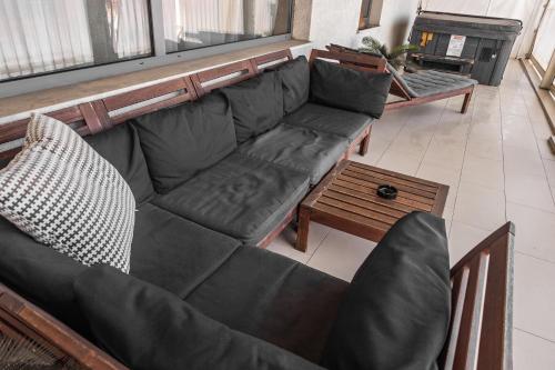 a living room with a black couch and a coffee table at Villa Boutique Lafayette in Bucharest