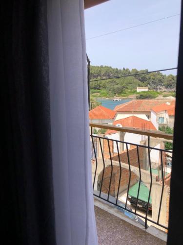 a room with a balcony with a view of a house at Anatoli House Il in Gaios