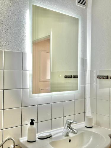 a white bathroom with a sink and a mirror at Basel & Frankreich nah - Airport I Parking I WLAN in Herten