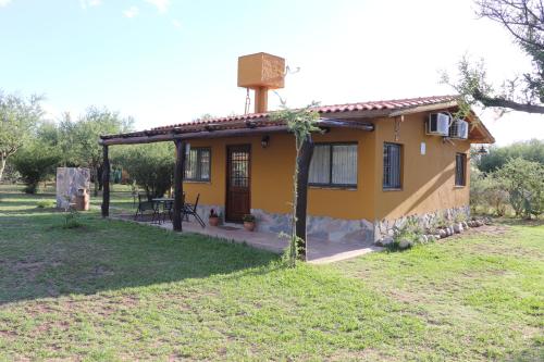 a small yellow house in a field at Arawi Cabaña in Merlo