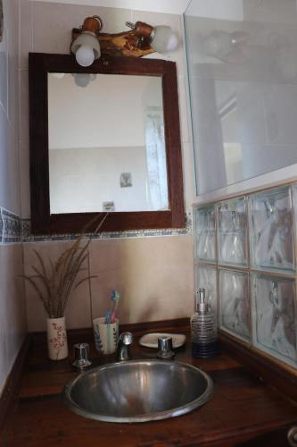 a sink in a bathroom with a mirror and a mirror at Arawi Cabaña in Merlo