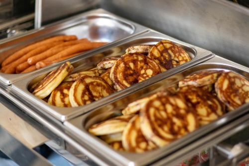 a tray of hot dogs and pretzels and bread at Noclegi Stadion Bed & Breakfast in Warsaw