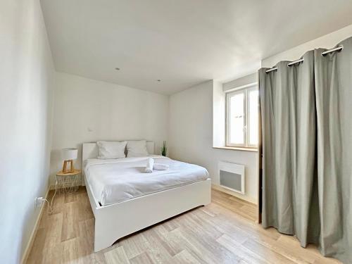 une chambre blanche avec un lit et une fenêtre dans l'établissement La Terrazza, cocon avec terrasse, à Limoges