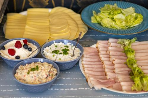 a table with plates of food and bowls of food at Noclegi Stadion Bed & Breakfast in Warsaw