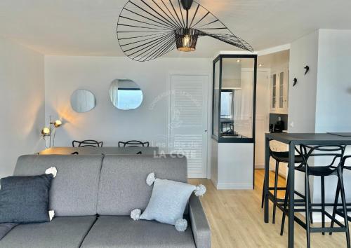un salon avec un canapé et une salle à manger dans l'établissement Bel Horizon - Vue mer et dunes, à Le Touquet-Paris-Plage