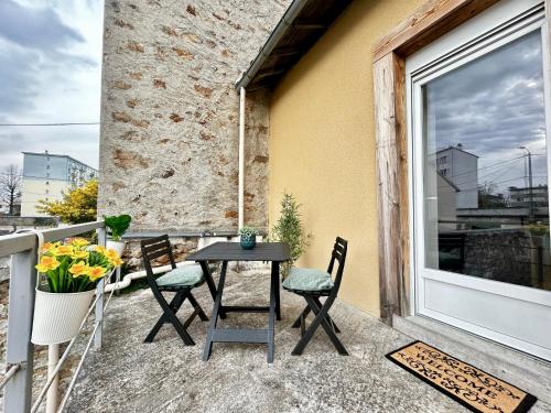 une table et des chaises sur un balcon avec une fenêtre dans l'établissement La Terrazza, cocon avec terrasse, à Limoges