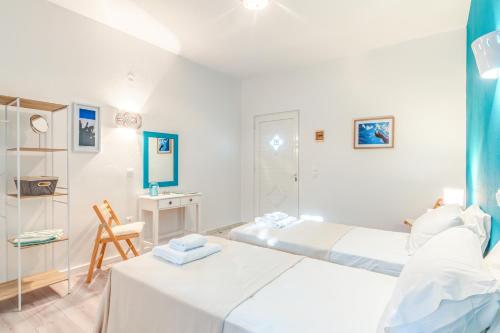 a white bedroom with two beds and a desk at Pleasure Corfù Fish in Agios Georgios