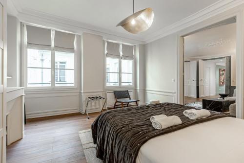 une chambre avec un grand lit avec deux serviettes dessus dans l'établissement 31#Louvre#Opera#Paris02 # 2bedrooms #AC, à Paris