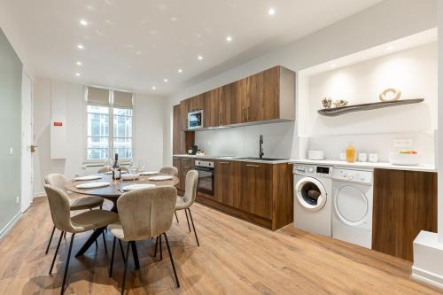 - une cuisine et une salle à manger avec une table et un lave-vaisselle dans l'établissement 31#Louvre#Opera#Paris02 # 2bedrooms #AC, à Paris