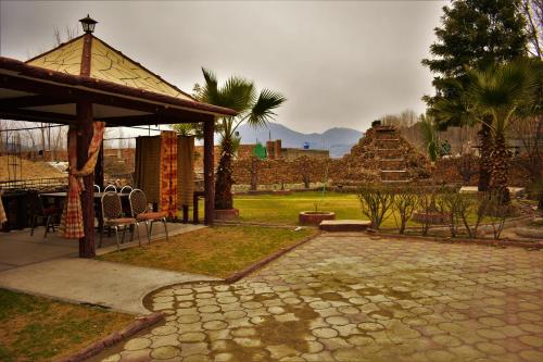 a garden with a pavilion and a table and chairs at Suvastu Resort Swat by Khan Familia Travels in Swat