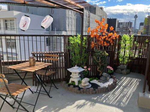 a patio with a table and chairs and flowers at Villa ayasuki Osaka namba in Osaka