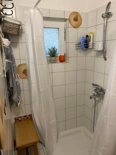 a shower with a white shower curtain in a bathroom at Vila Agroturizam Kućica Mostar-Welcome bikers in Mostar