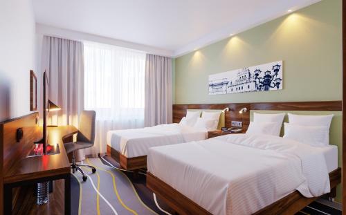 a hotel room with two beds and a television at Hampton by Hilton Brest in Brest