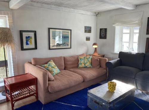 a living room with a couch and a table at By The Bay A Thatched House Lies So Beautifully in Føns