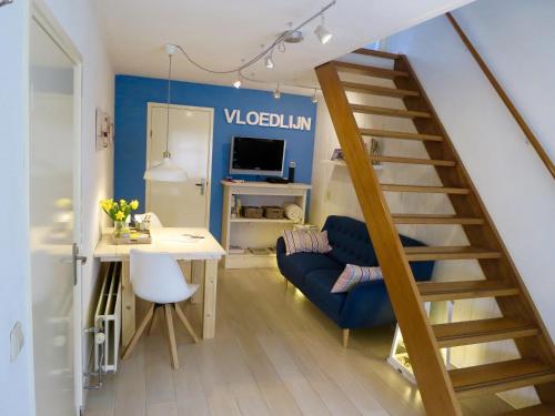 a living room with a staircase and a blue wall at B&B Vloedlijn Texel in Den Burg
