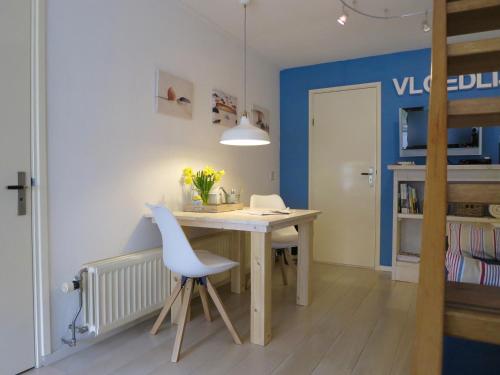 Habitación con escritorio, silla y mesa. en B&B Vloedlijn Texel en Den Burg