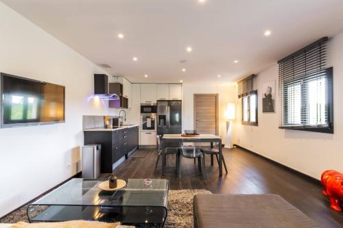 une cuisine et un salon avec une table et des chaises dans l'établissement Joli bas de maison - Jardin et piscine privative, à Mougins