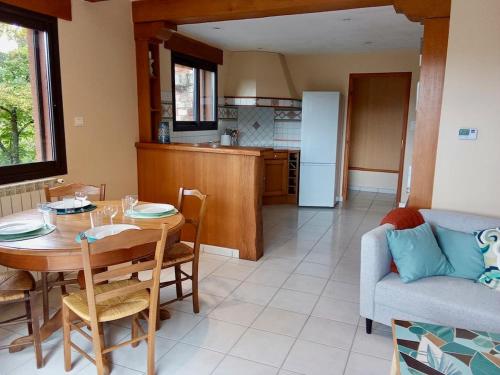 - une cuisine et une salle à manger avec une table et un canapé dans l'établissement Gîte au coeur de la muse, à Castelnau-Pégayrols