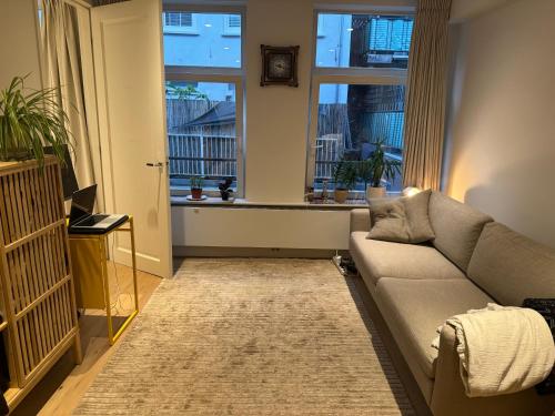 a living room with a couch and a window at Apartment in Oude-Pijp in Amsterdam