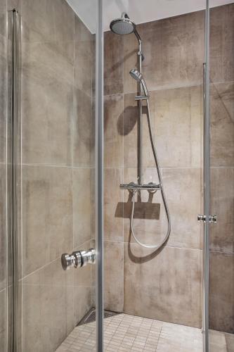 a shower with a glass door in a bathroom at TotalApartments Vervet Apartment Hotel in Tromsø