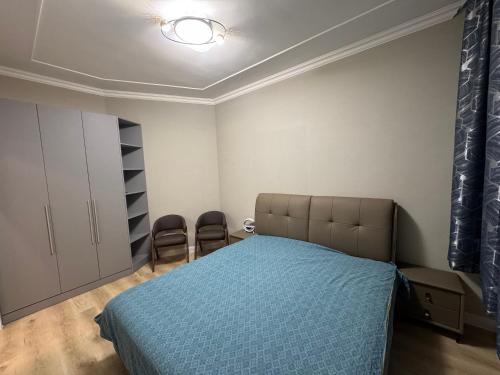 a bedroom with a bed and two chairs in it at EBTM Apartments Hotel in Ulaanbaatar
