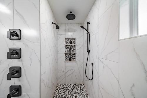 a bathroom with white marble walls and a walk in shower at Spacious 3BR Home Sleeps 8 Private Backyard in Everett