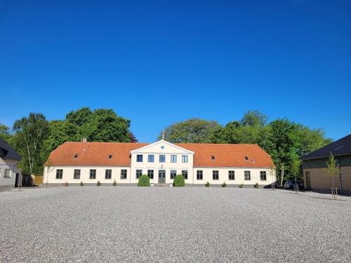 a large white building with a red roof at Privat lejlighed på landejendommen Frederiks-Eg in Herlufmagle