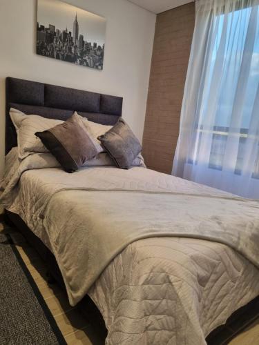 a bedroom with a large bed with a window at Loft con Estilo y Comodidad in Bogotá