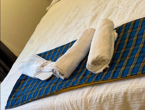 a bed with two towels and a blue andermott at Nairobi Deluxe Apartment 15 min to JKIA, 30min to CBD in Nairobi