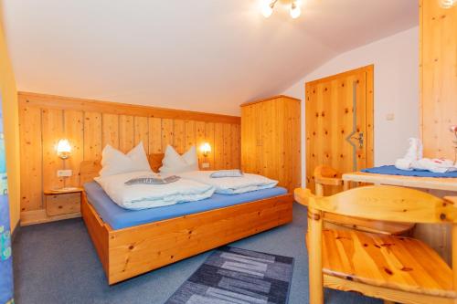 a bedroom with a bed and a wooden wall at Haus Traudi in Rauris