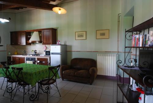 a kitchen with a table and a chair and a refrigerator at Spoleto by the pool in Spoleto