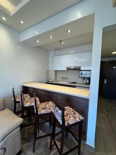 a kitchen with a bar with chairs and a counter at Ny Suites in Beirut
