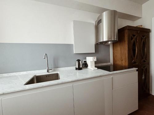 a kitchen with white cabinets and a sink at Villa Sofia in Querceta