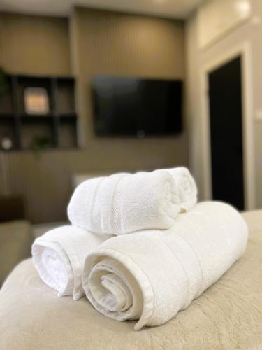 a pile of white towels sitting on top of a bed at Luxury Guest House in Vibrant London Area in London