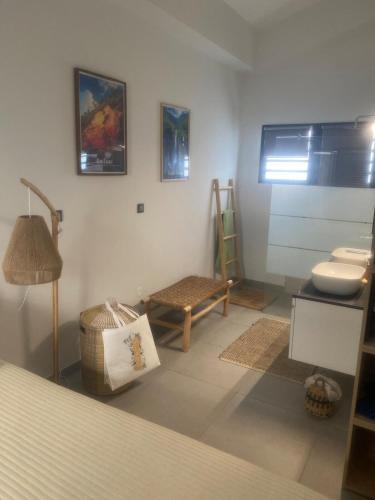 a bathroom with a sink and a toilet and a stool at La KAZIZA plage de grand anse in Petite Île