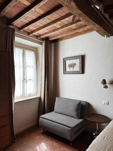 a bedroom with a chair and a window at Villa Sofia in Querceta