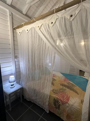 a bedroom with a bed with a mosquito net at Au Bel'vue chez Sandrine "Gite & Chambre d'hôtes" in Le Moule
