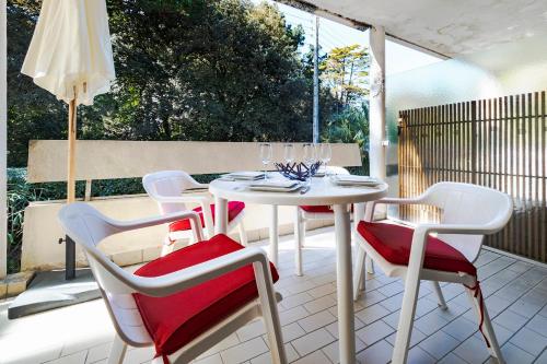 un patio avec une table, des chaises et un parasol dans l'établissement Studio tout à pied La Baule Les Pins 150m plage, à La Baule