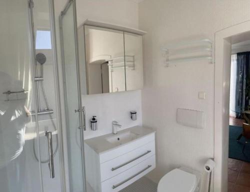 a white bathroom with a sink and a toilet at Wohnung 3 mit Balkon und Bergblick in Grossgmain