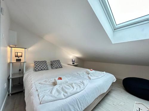 a bedroom with a white bed with towels on it at Le pilier G un cocon confortable proche du centre in Reims