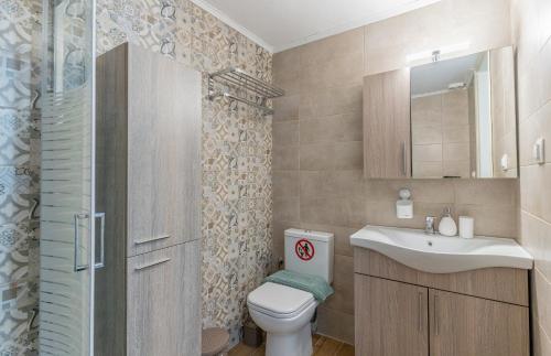 ein Badezimmer mit Toilette und Waschbecken in der Unterkunft Beachfront Bliss by halu! Spacious vacation house in Nea Skioni